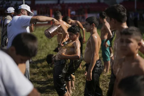 A young wrestler is doused in oil