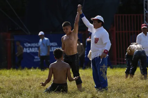 A referee announces the victory of a young wrestler
