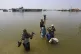 Victims of flooding from monsoon rains carry belongings sal