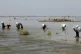 Victims of heavy flooding from monsoon rains crowd carry rel