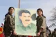 Kurdish fighters hold a portrait of PKK leader Abdullah Ocal