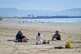People rest after exercise on the beach in hot weather in Sw