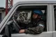 TENSIONS: M23 rebels (background) walk past a UN peacekeeper
