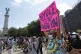 A protester holds a sign as she and others gather to listen 