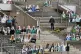 Workers clean the supporters tribune where portraits of fans