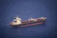 The Etienne merchant ship pulls up alongside a small wooden 