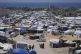 Displaced Palestinians walk through a makeshift tent camp in the Muwasi area of Khan Younis, in the Gaza Strip, on Monday, May 5, 2025