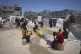Palestinian children wait in line to collect water in Gaza City, May 24, 2025