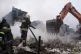 A rescue worker extinguish a fire of a house destroyed by a Russian strike in Markhalivka village, Kyiv region, Ukraine, May 25, 2025