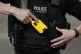 An officer holsters the new Taser, April 12, 2023