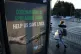 A person walking passed a Coronavirus related poster on a phone box outside Glasgow Royal Infirmary