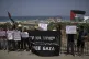 People wave the Palestinian flag and hold signs in support of Greta Thunberg and other activists who tried to deliver aid to Gaza before their ship was seized and they were detained by Israeli forces, near the port of Ashdod, Israel, June 9, 2025