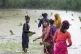 Indian farmer girls stand in the rain in a rice field on the outskirts of Lucknow, in the northern Indian state of Uttar Pradesh, June 22, 2025