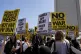Anti-war demonstrators hold signs outside the Wilshire Federal Building in Los Angeles, June 22, 2025, following U.S. airstrikes on Iran's nuclear facilities
