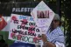 A protester of the Palestine Solidarity Campaign against the tournament's sponsor Barclays holds posters outside the Wimbledon Tennis Championships in London, June 30, 2025