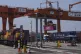 A machine loads a container on trucks as a train loaded with containers leave the Chongqing Railway Container Terminal Station in southwest China's Chongqing Municipality on May 20, 2025