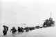 U.S. reinforcements wade through the surf from a landing craft in the days following D-Day and the Allied invasion of Nazi-occupied France at Normandy in June 1944 during World War II
