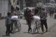 Palestinians carry bags of flour looted from aid trucks in Khan Younis, southern Gaza Strip, June 26, 2025