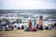 People chat on a hill near the Glastonbury sign during the Glastonbury Festival at Worthy Farm in Somerset, June 26, 2025