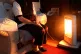 An elderly lady sitting at home with her electric fire on