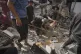 Palestinians search for survivors amid the debris of a building destroyed by an Israeli airstrike in Gaza City, July 15, 2025