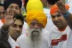 Centenarian marathon runner Fauja Singh, center, smiles after finishing a 10-kilometer race, held as part of the annual Hong Kong Marathon, in Hong Kong, Feb. 24, 2013
