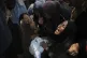 Maysara Adwan, left, mourns as she holds the body of her 11-year-old son, Qais, who was killed in an Israeli airstrike on a school in Gaza that has been used as a shelter, during his burial at Al Shifa Hospital in Gaza City, Friday, July 25, 2025