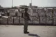 An Israeli soldier stands beside humanitarian aid packages awaiting pickup on the Palestinian side of the Kerem Shalom crossing in the Gaza Strip, Thursday, July 24, 2025, during a media tour organized by the Israeli army
