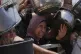 Palestinians struggle to get donated food at a community kitchen, in Gaza City, northern Gaza Strip, July 26, 2025