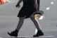 A school girl holds her phone while crossing a street in Sydney, on November 8, 2024