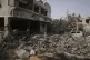 A Palestinian girl stands atop the rubble of the Al-Aimawi family's home that was destroyed by Israeli airstrikes in Al-Zawaideh, Gaza Strip, July 1, 2025