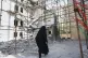 A woman walks past a building damaged in a deadly June 13 Israeli airstrike at a residential compound in Tehran, Iran, July 19, 2025