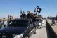 In this file photo released on May 4, 2015, by a militant website, which has been verified and is consistent with other AP reporting, Islamic State militants drive in a convoy through Tel Abyad, northeast Syria
