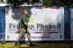 A man walks past a banner for Feile an Phobail, also known as the West Belfast Festival, in the Falls Park, August 2022