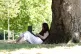 A person under a tree in Greenwich Park, London, July 10, 2025