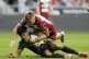 Catalans Dragons Guillermo Aispuro-Bichet is tackled by Wigan Warriors Harvey Hill during the Super League match at Brick Community Stadium, Wigan, July 25, 2025