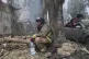 A rescue worker rests as others put out a fire of a building destroyed by a Russian drone strike in Zaporizhzhia, Ukraine, July 7, 2025