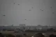 Parachutes drop supplies into the Gaza Strip as seen from southern Israel, Tuesday, Aug. 12, 2025.