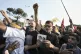 Hezbollah supporters chant slogans as they gather to welcome Ali Larijani, head of Iran's National Security Council, outside Rafik Hariri International Airport in Beirut, Lebanon, Wednesday, Aug. 13, 2025