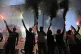 Protesters hold flares during a rally to protest the arrival of a cruise ship with Israelis, in Piraeus port, Greece, August 14, 2025