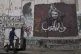 A man walks past a mural depicting the Palestinian leader Marwan Barghouti, with a message that reads in Arabic, 