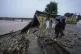 Residents look at the remains of their houses, damaged by flash floods at the banks of Tawi river in Jammu, India, August 27, 2025