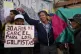 A protester holds a sign that reads in Spanish, 