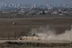 An Israeli tank moves through an area near the Israeli-Gaza border, as seen from southern Israel, August 20, 2025