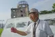 Kunihio Iida, atomic bomb survivor and a volunteer guide the iconic exhibition hall best known as the Atomic Bomb Dome speaks in English to foreign visitors on July 9, 2025, in Hiroshima, western Japan