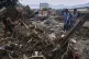 Villagers collect usable items through the rubble of their partially damaged home following Friday's flash flooding at a neighbourhood of Pir Baba, an area of Buner district, in Pakistan's northwest, August 17, 2025