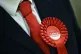 A Labour Party supporter wears a rosette