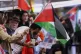 Protestors wave flags as they wait for activists to arrive at Brussels International Airport in Zaventem, Belgium, October 7, 2025, after being deported from Israel for taking part in a Gaza-bound aid flotilla