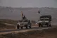 Israeli soldiers move near the Israeli-Gaza border, as seen from southern Israel, October 9, 2025