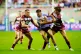 Hull KR's Tom Davies (centre) is tackled by Wigan Warriors' Sam Walters during the Betfred Super League match at The Brick Community Stadium, Wigan, August 15, 2025